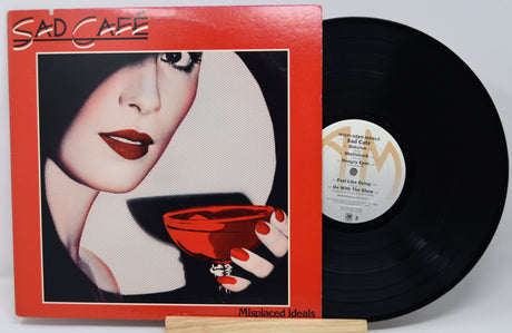 Vinyl record with a cover featuring a woman's face and a red cup, labeled 'Sad Cafe'.