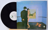 Vinyl record with cover featuring an artistic illustration of a couple and a bow.