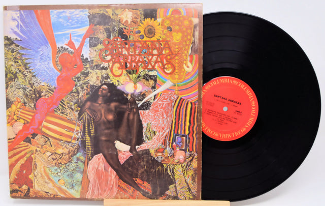 A vinyl record album for Santana's 'Blind Gypsy' shown with its illustrated cover on the left and the black LP record partially pulled out on the right, photographed against a plain white background.