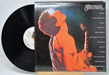 'Santana Festival' Vinyl record with cover featuring a person playing guitar, on a light gray background