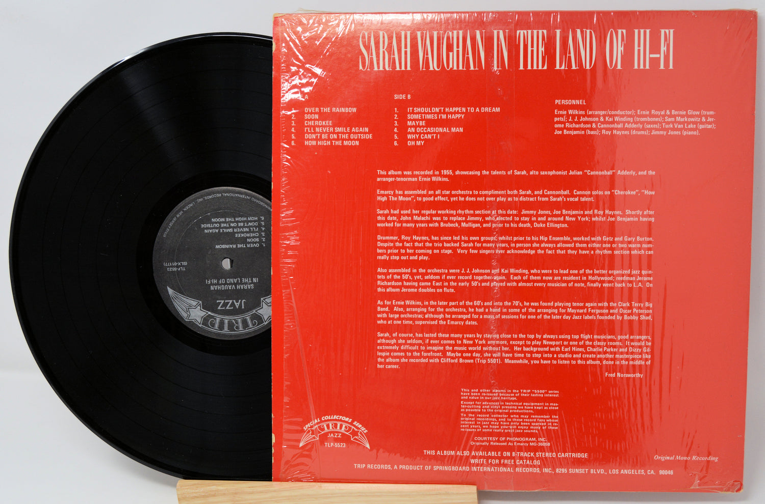 Vinyl record with red cover featuring text and a logo on a white background