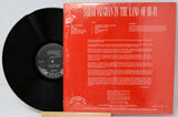 Vinyl record with red cover featuring text and a logo on a white background