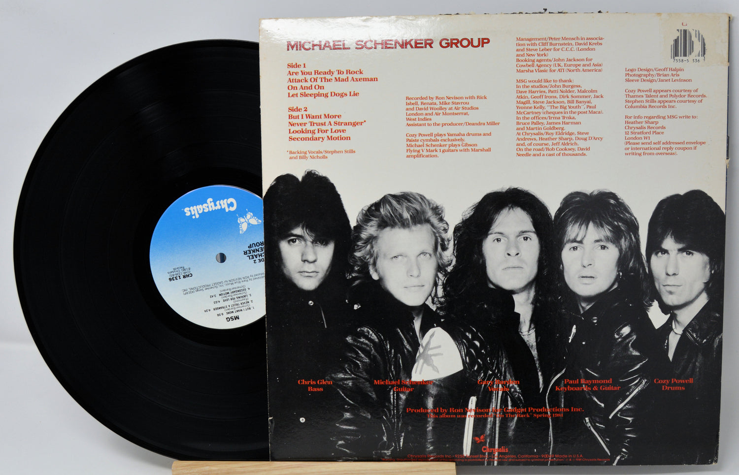 Vinyl record with cover featuring a band lineup and text on a gray background