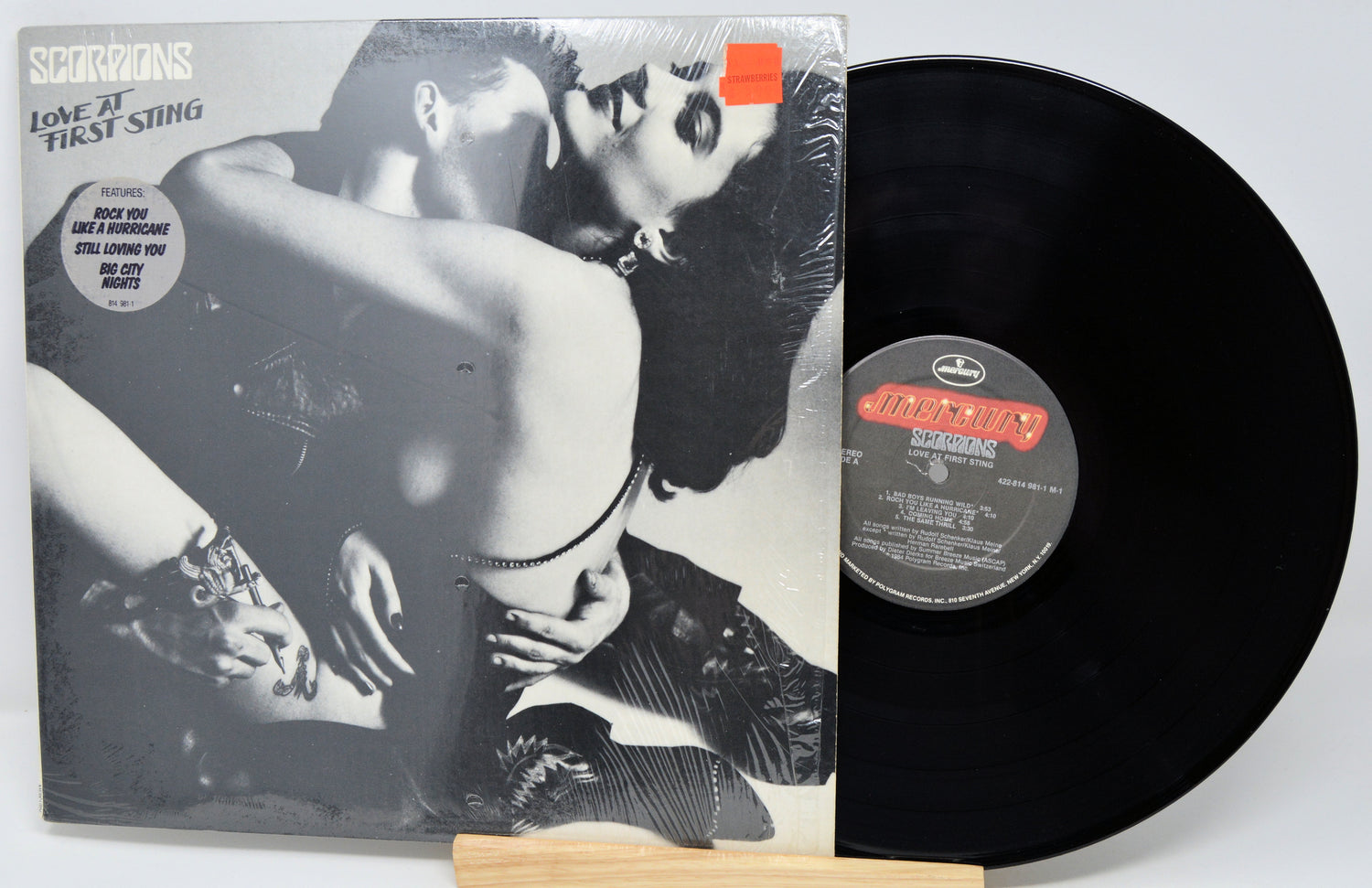 Vinyl record with a colorful cover featuring images of a person playing guitar and sitting.