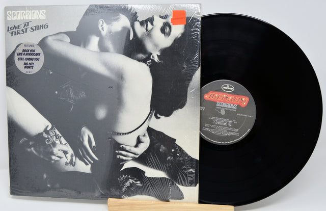 Vinyl record with a colorful cover featuring images of a person playing guitar and sitting.