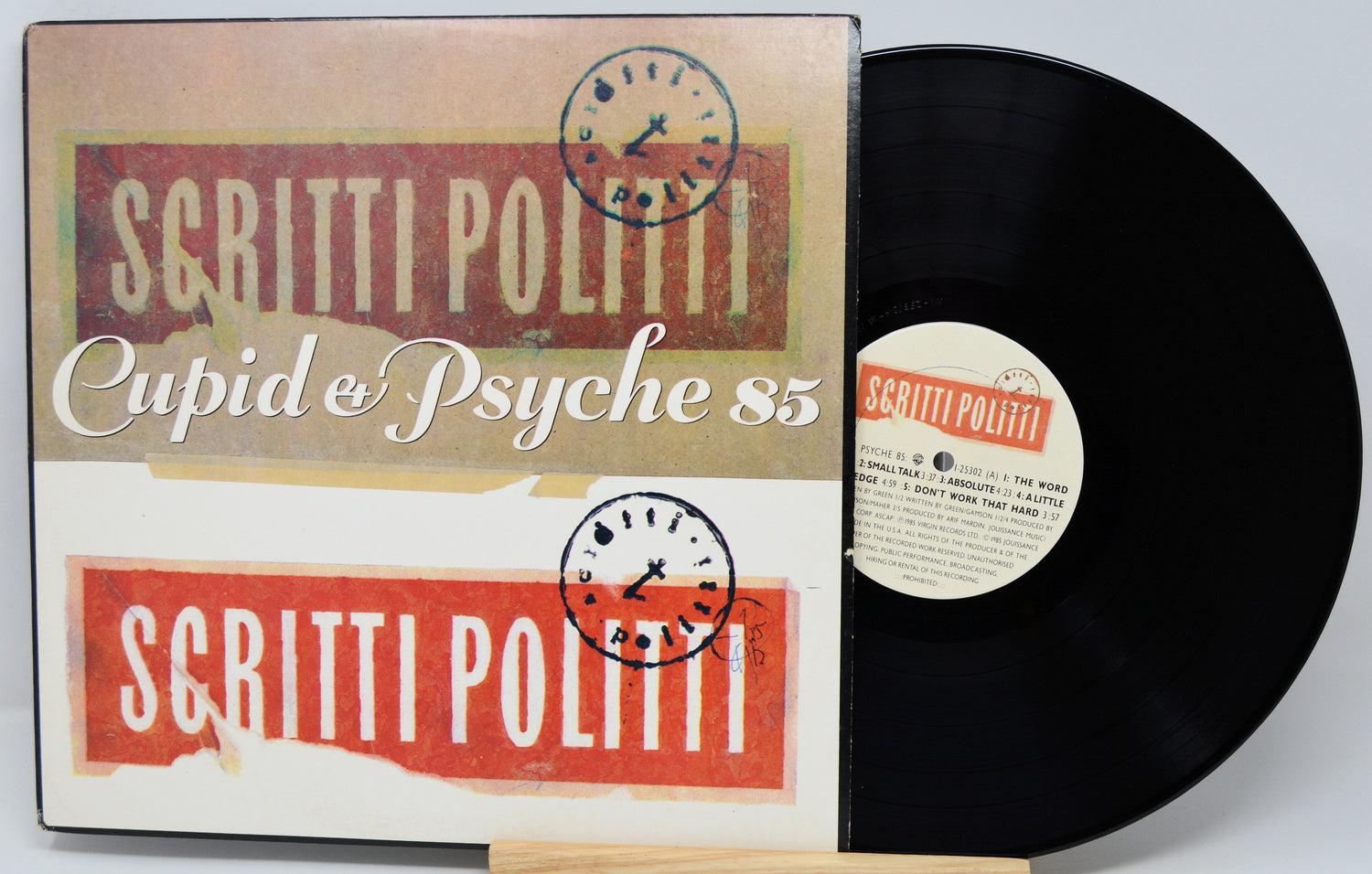 Vinyl record with 'Scritti Politti' album cover featuring red and beige design.