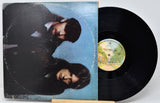 Vinyl record with a blue cover featuring two people and a visible label.