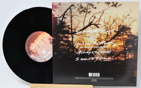 Vinyl record with cover featuring a sunset and text