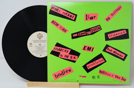 Vinyl record with a green cover featuring black and red text on a white background
