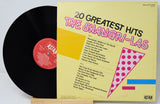 Vinyl record with yellow cover featuring '20 Greatest Hits' by The Shangri-Las on a light gray background.