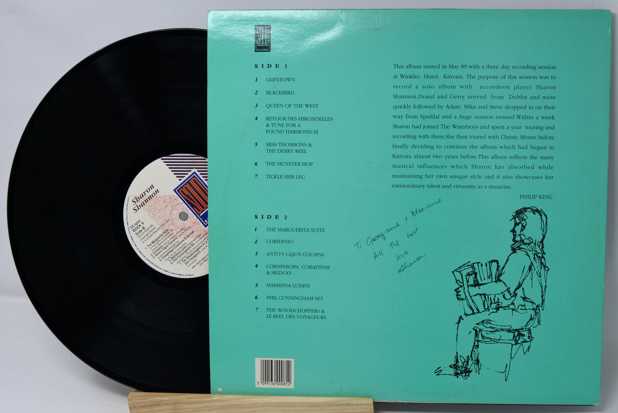 Vinyl record with green label showing text and a silhouette of a person holding records.
