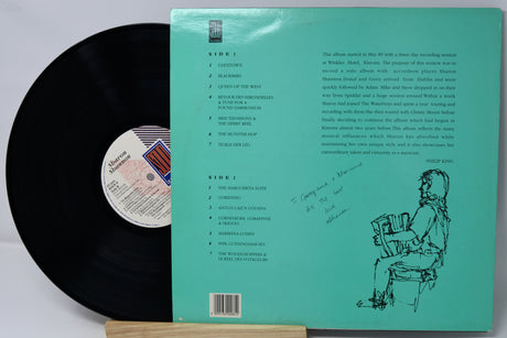 Vinyl record with green label showing text and a silhouette of a person holding records.
