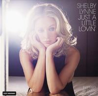 Album cover for Shelby Lynne's 'Just a Little Lovin'' featuring a portrait of the blonde singer in a dark top against a bright, hazy white background with black text on the right.