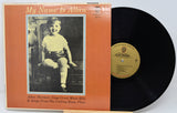 Vinyl record with orange cover featuring a black and white photo of a child, on a light gray background.