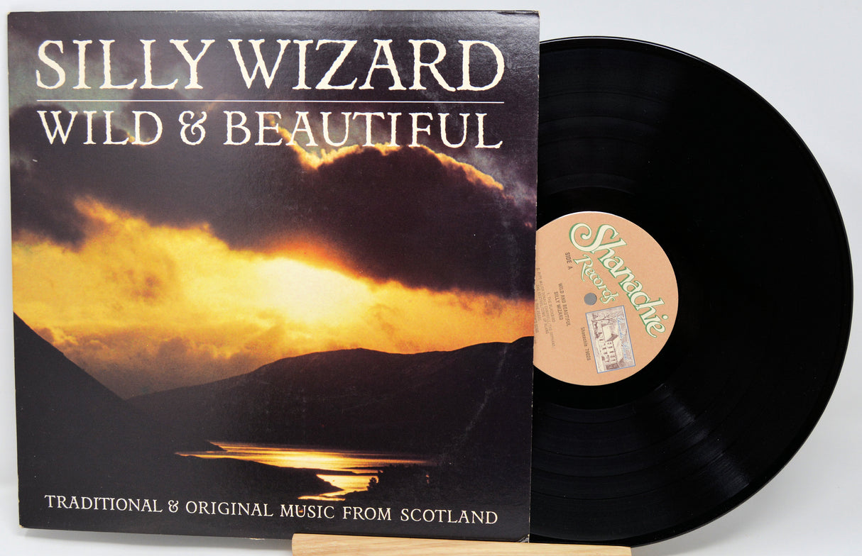 Vinyl record with 'Silly Wizard Wild & Beautiful' album cover showing a sunset over water.