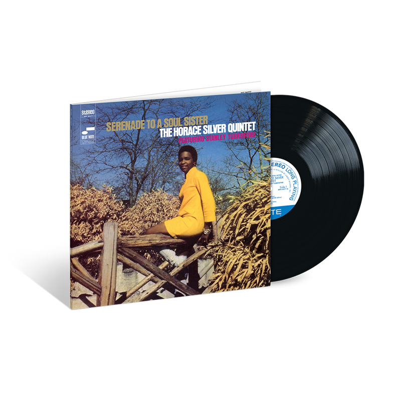 A vinyl record of Horace Silver's album 'Serenade To A Soul Sister' with the artist seated on a wooden structure in a natural setting, smiling, with the album cover in a blue and white color scheme.