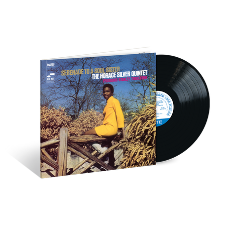 A vinyl record of Horace Silver's album 'Serenade To A Soul Sister' with the artist seated on a wooden structure in a natural setting, smiling, with the album cover in a blue and white color scheme.