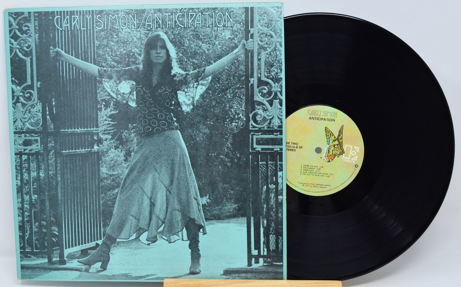 Vinyl record with cover featuring a person and butterfly design on a decorative background