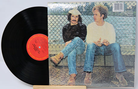 Vinyl record with a cover featuring two people sitting on a bench.