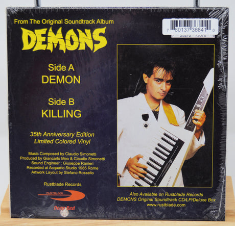 Vinyl record cover for 'Demons' with a person holding a keyboard, featuring text about the album's sides and release details.