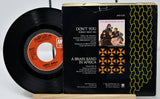 Vinyl record and its cover with 'Don't You (Forget About Me)' by Simple Minds on a white background
