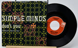 Vinyl record with 'Simple Minds' album cover featuring a geometric pattern.