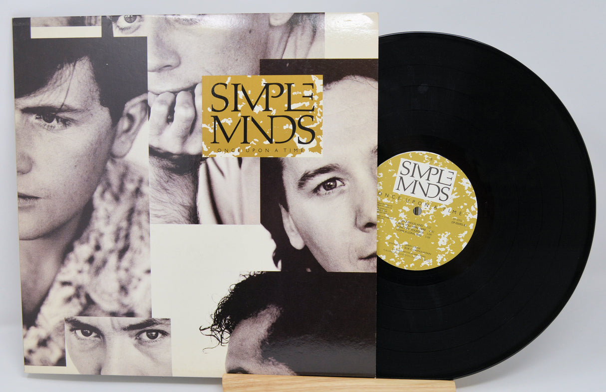 Vinyl record with 'Simple Minds' cover featuring black and white portraits.