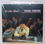 Vinyl record album cover for Frank Sinatra's 'No One Cares', sealed in plastic shrink wrap and displayed upright on a small wooden stand against a white background.