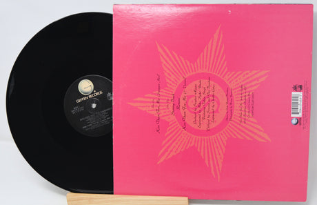 Vinyl record with a pink cover featuring a sun design on a white background