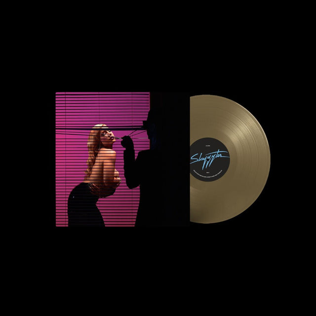 A vinyl record partially pulled from its sleeve on a black background. The sleeve features a woman in sunglasses against pink horizontal blinds, and the record is gold with a dark blue script label.