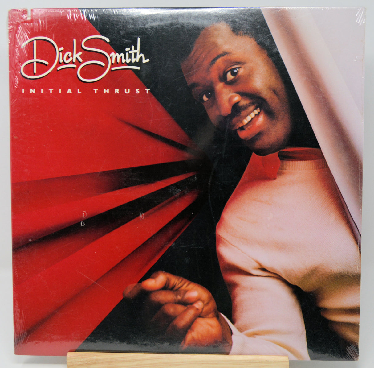 Vinyl record cover with a person and red design, featuring the text 'Dick Smith Initial Thrust'.