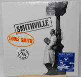 Louis Smith's 'Smithville' Blue Note vinyl record album, still sealed in its original plastic shrink wrap. The cover features a black and white photograph of a man leaning against a street lamp, with a blue 'Blue Note' sticker in the bottom right corner.