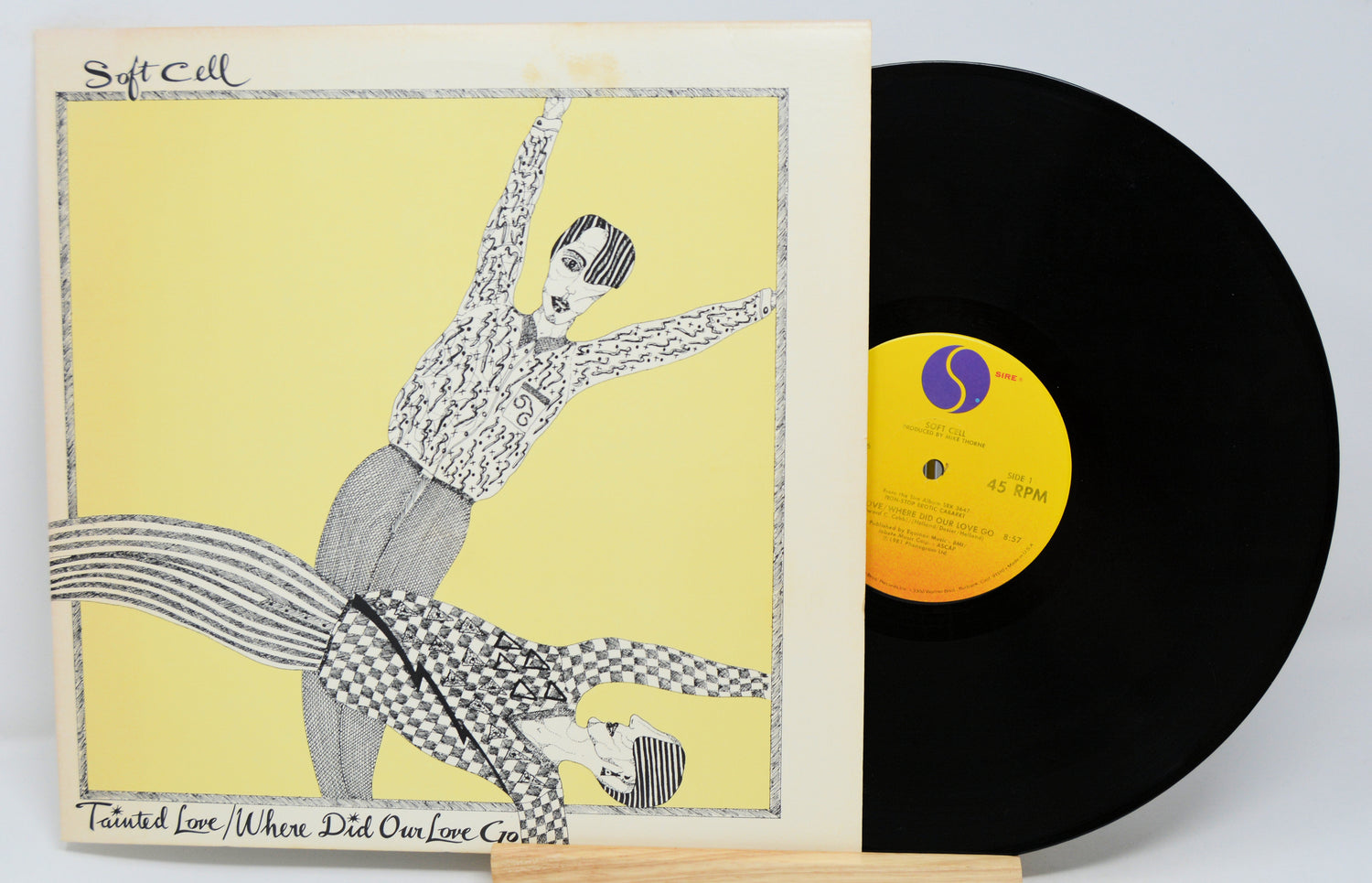 A vinyl record titled 'Soft Cell - Tainted Love/Where Did Our Love Go' with a graphic cover art featuring a stylized drawing of two figures.