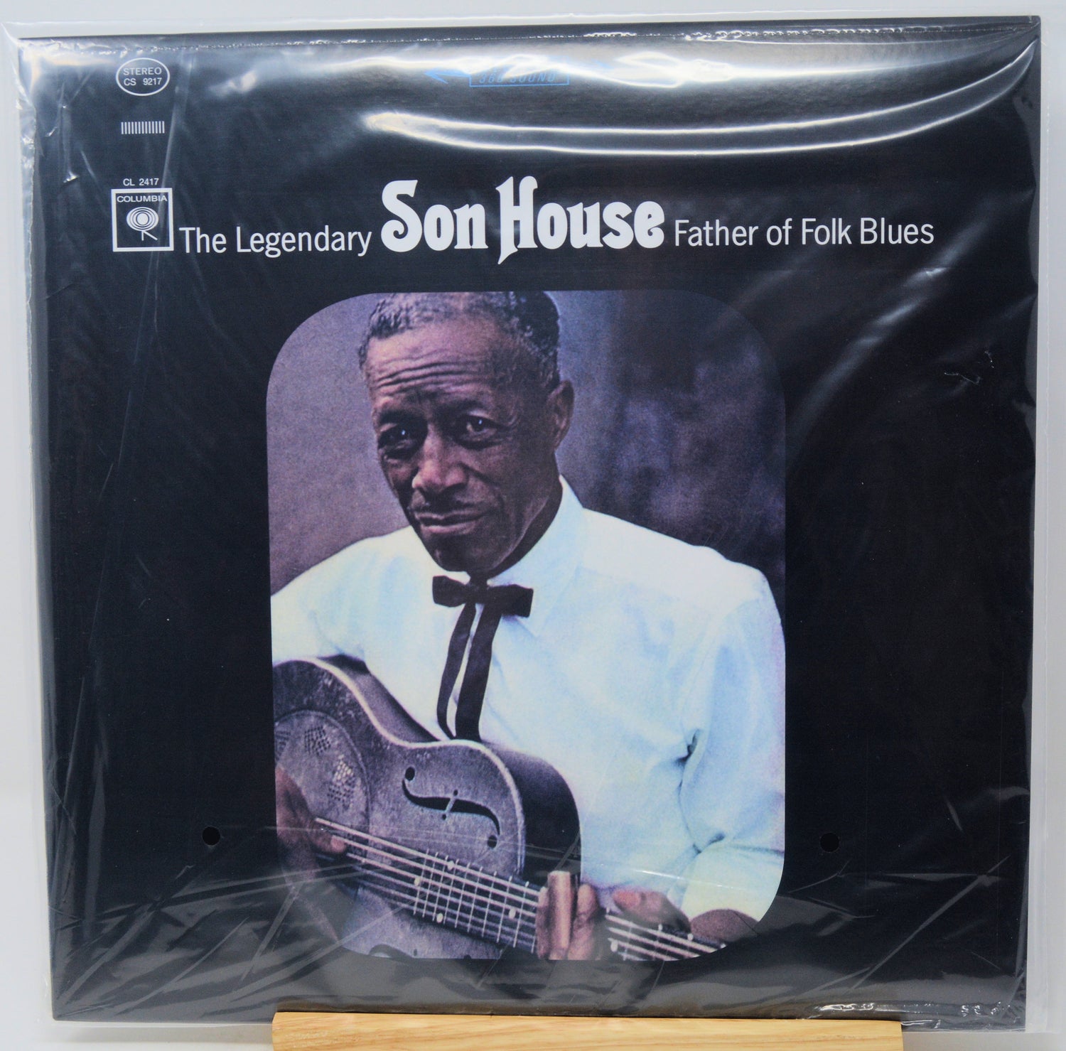 Vinyl record album cover for 'The Legendary Son House - Father of Folk Blues' on a black background, wrapped in clear plastic with visible creases. The cover features a portrait of Son House holding a guitar, with white text and a small Apple Records logo in the upper left.