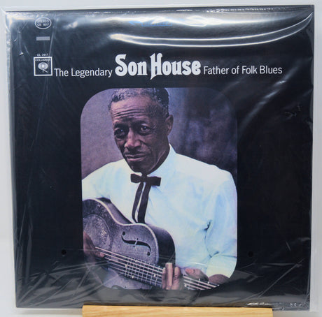 Vinyl record album cover for 'The Legendary Son House - Father of Folk Blues' on a black background, wrapped in clear plastic with visible creases. The cover features a portrait of Son House holding a guitar, with white text and a small Apple Records logo in the upper left.