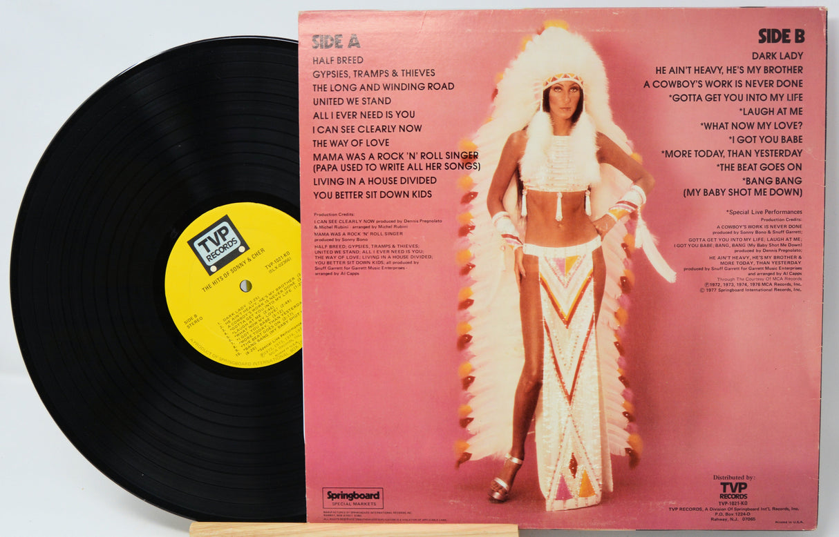 Vinyl record with a colorful cover featuring a person in a costume on a light gray background