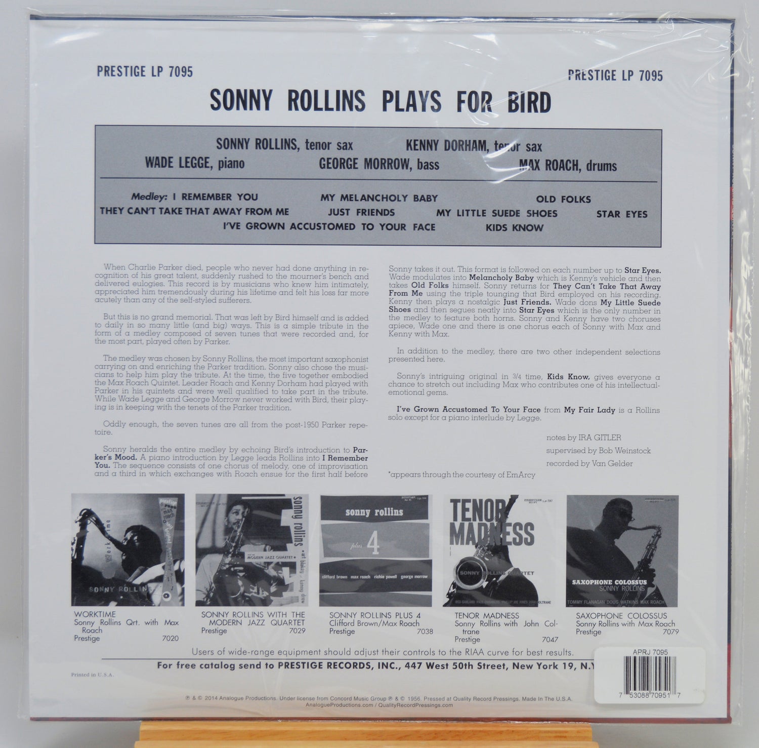 The back cover of a vinyl record sleeve for Prestige LP 7095, featuring Sonny Rollins playing for bird, photographed inside a clear plastic protective sleeve. The cover has a white background with black text, a central gray band listing band members, and several small black-and-white photos at the bottom.