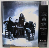 Album cover with a black and white photo of four people around a table, with text on the right side.
