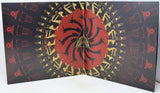 A folded vinyl record sleeve or album cover featuring a central red circular design with black spiral shapes and a gold triangle logo, surrounded by a black background with repeating red and gold mechanical illustrations.