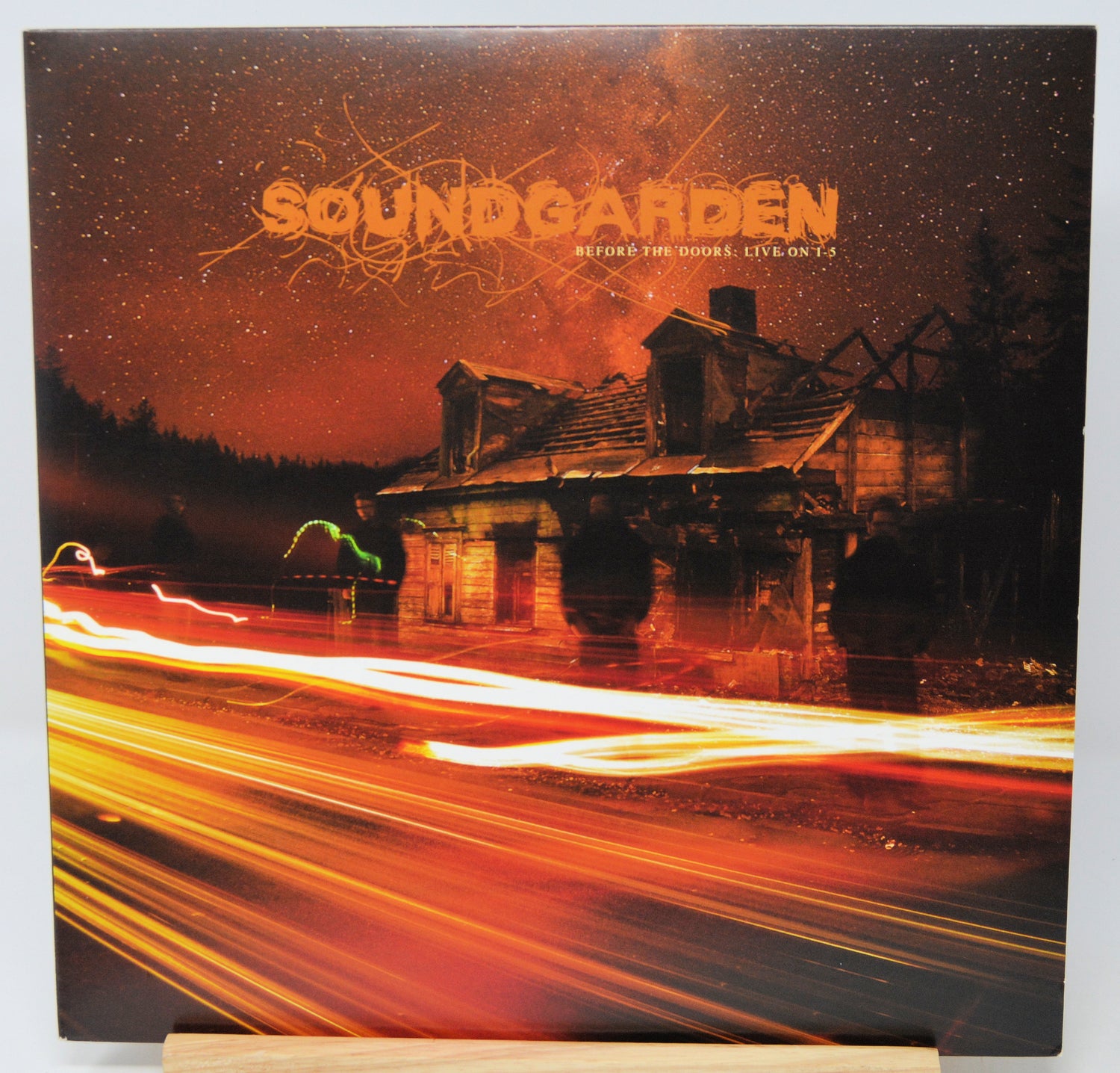 Soundgarden 'After the Fire: Live on 75' vinyl record cover, displayed on a wooden stand against a white background.