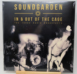Soundgarden 'In & Out of the Cage: The 1990s Radio Broadcasts' vinyl record cover, shrink-wrapped and displayed upright on a small wooden stand against a light gray background.