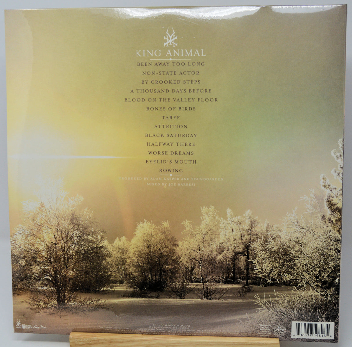 King Animal vinyl record album cover back, featuring a sepia-toned forest landscape with sun rays and a list of track titles on a white background.