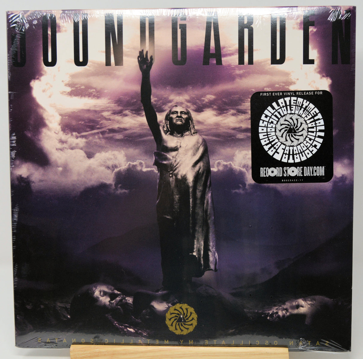 Soundgarden 'Fallen' CD album cover, sealed in plastic shrink wrap with a collectible sticker on the right, displayed on a wooden stand against a white background.