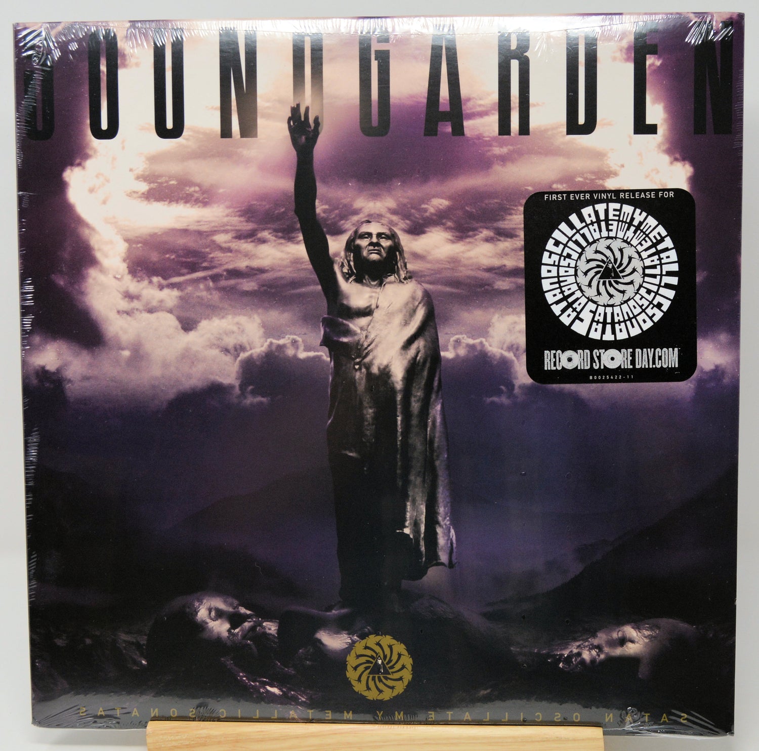 Soundgarden 'Fallen' CD album cover, sealed in plastic shrink wrap with a collectible sticker on the right, displayed on a wooden stand against a white background.