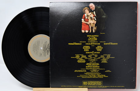 Vinyl record with cover featuring a couple and dog, on a white background