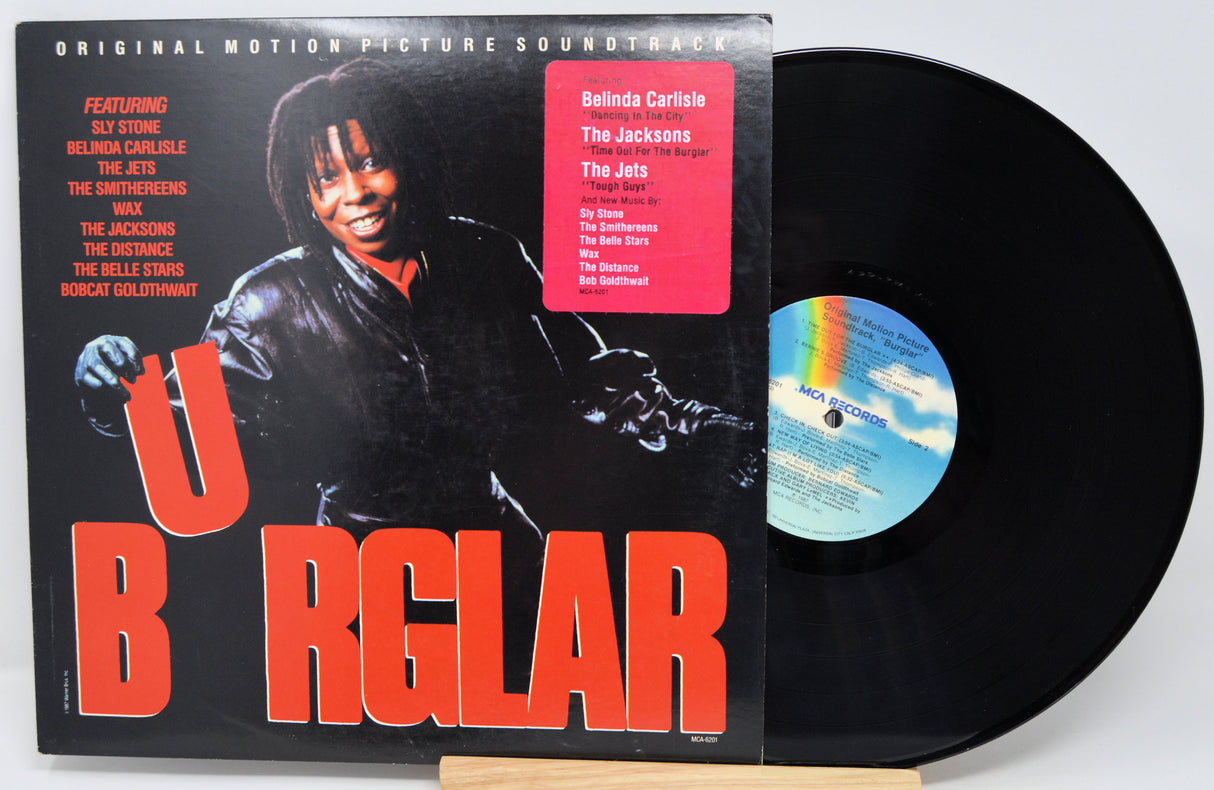 Vinyl record with cover featuring a person playing guitar, on a white background