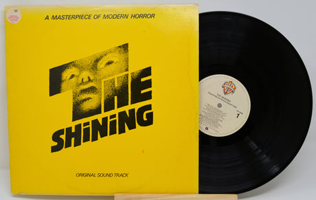 Vinyl record and cover of 'The Shining' with yellow cover and black disc.