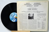 Vinyl record with cover featuring text and a black and white photo of a man.