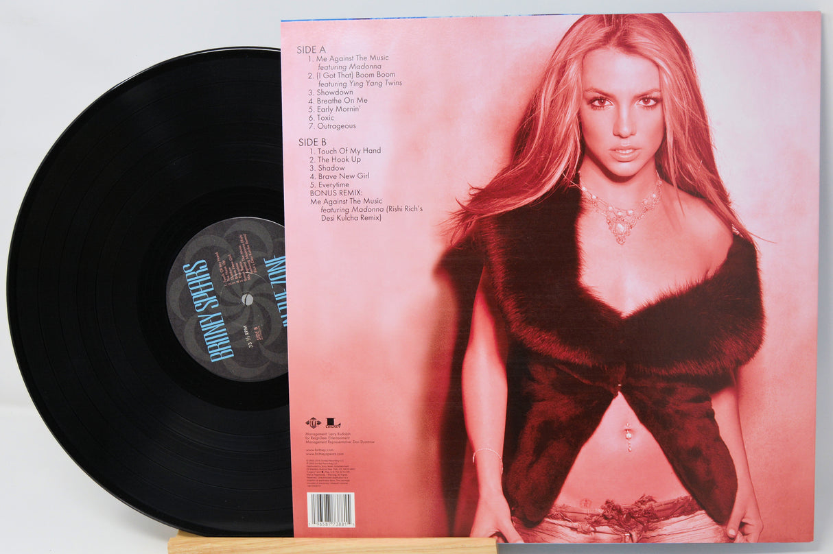 Vinyl record with a cover featuring a person in a red dress on a light pink background