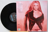 Vinyl record with a cover featuring a person in a red dress on a light pink background